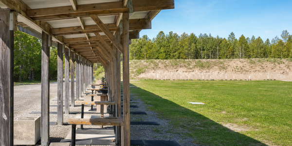 Generated illustrative photograph of an unnamed outdoor shooting-range facility with several covered firing points.