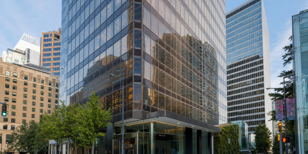 The glass-clad corner of the 701 West Georgia Street building rises above its public sidewalk entrance in Vancouver.