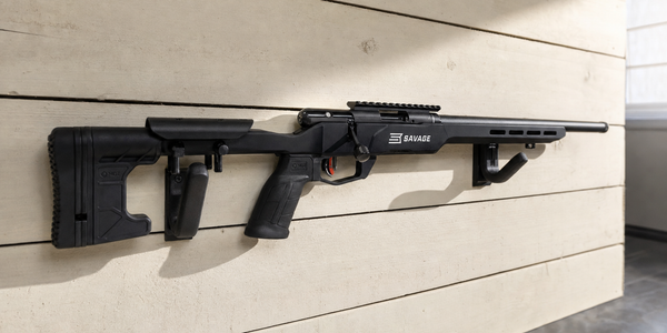 Black Savage B22 Precision on two workshop wall supports, with a machined chassis and daylight shadow.
