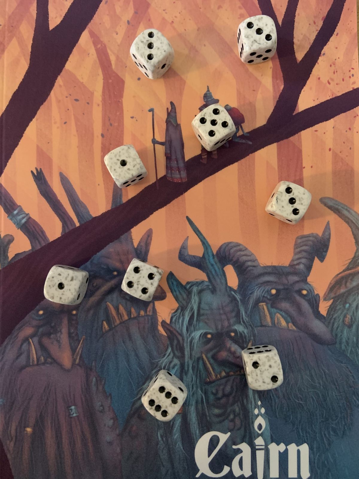 Nine six-sided dice rolled on the cover of the Cairn 2e Warden's Guide