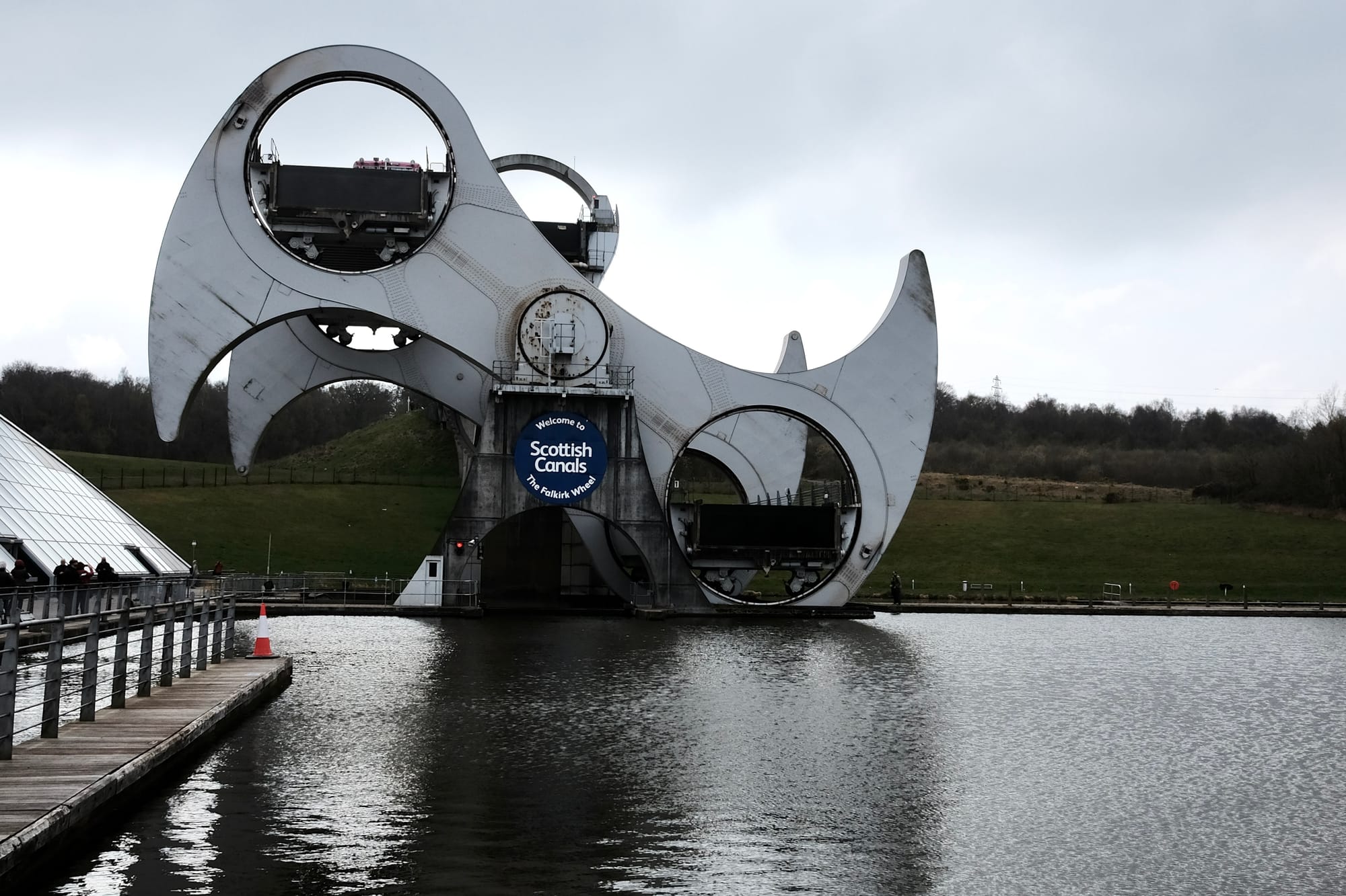 The Falkirk Wheel – a large grey metal boat lift shaped like two gigantic axe heads connected to a spindle