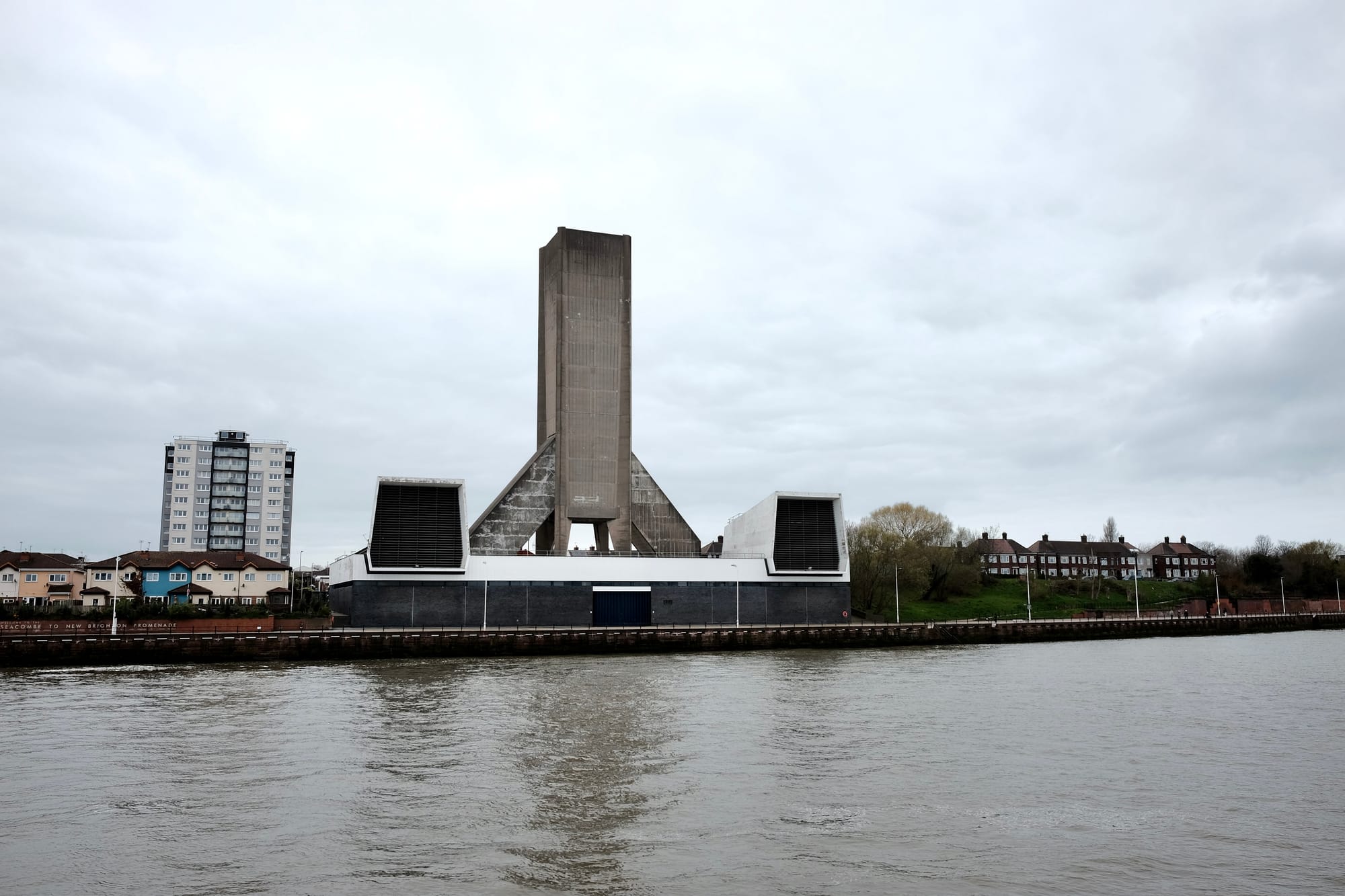 The concrete tower of the Kingsway Tunnel vent rises above the Birkenhead shoreline.