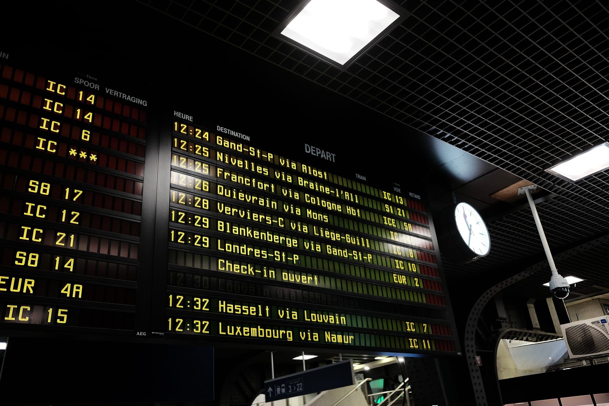 A departures board at Brussels Midi station lists train times and destinations in bright yellow writing
