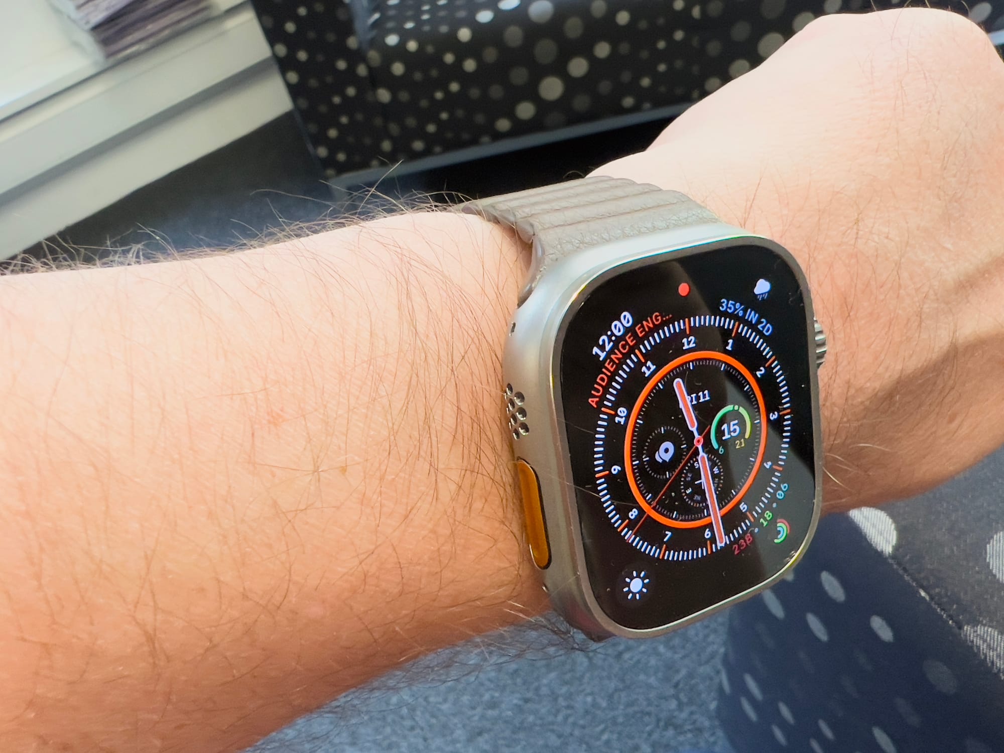 An Apple Watch Ultra with an old leather magnetic strap. 