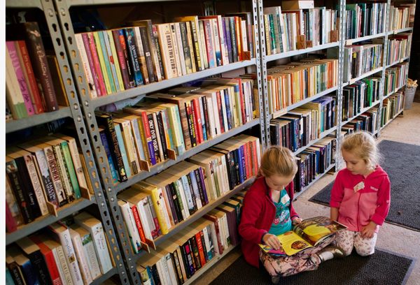Two girls read in a second-hand bookshop