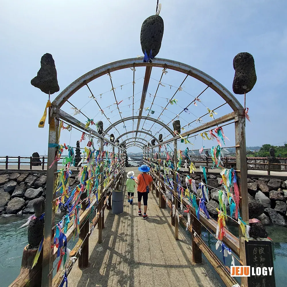 [6] Ribbons tied to the arched passage out on the breakwater — small, hopeful gestures toward the sea. — webp_20200804_112512.webp