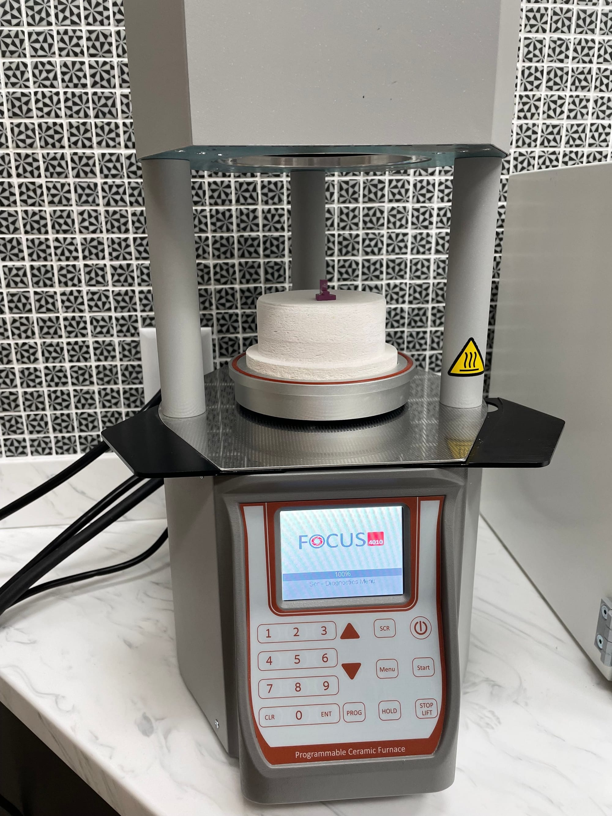 Dental sintering furnace baking a stained ceramic crown at Longworth Dental's in-house lab