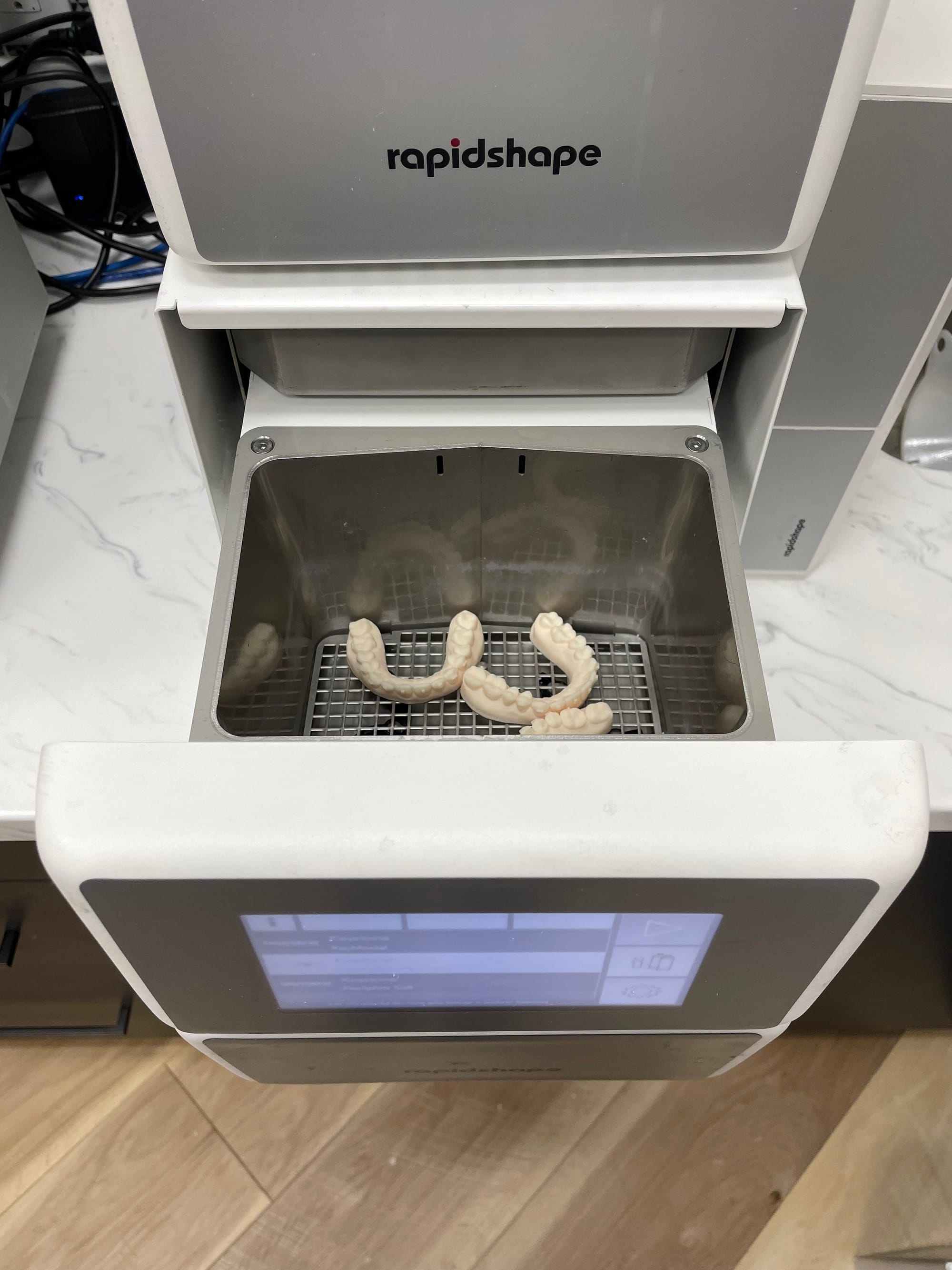 Wash station cleaning freshly printed models in isopropyl alcohol