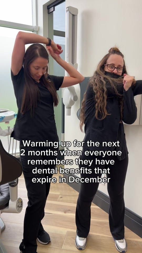Two Longworth Dental Courtice team members stretch and warm up together in an operatory.