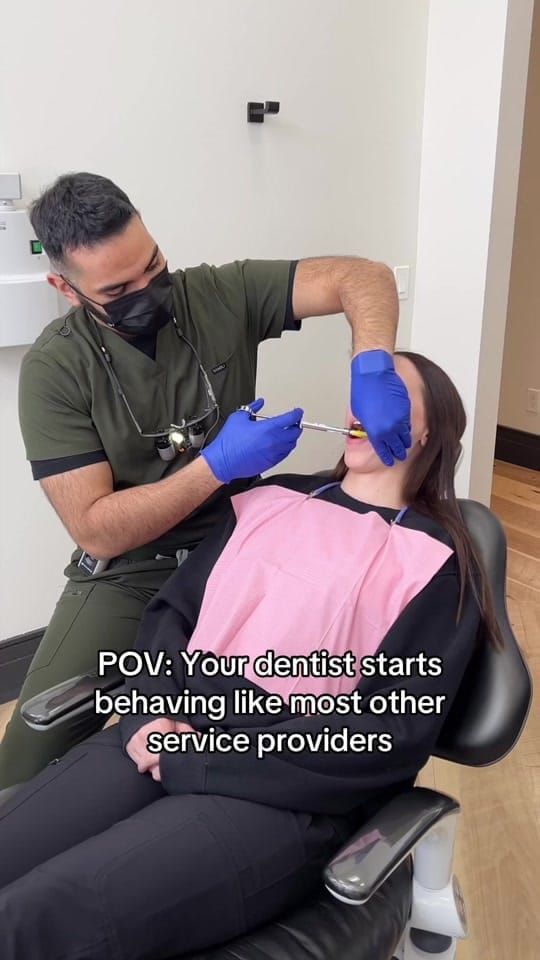 Dr. Zuhair Waheed, in green scrubs and mask, administers an injection to a patient reclined in the chair at Longworth Dental Courtice.