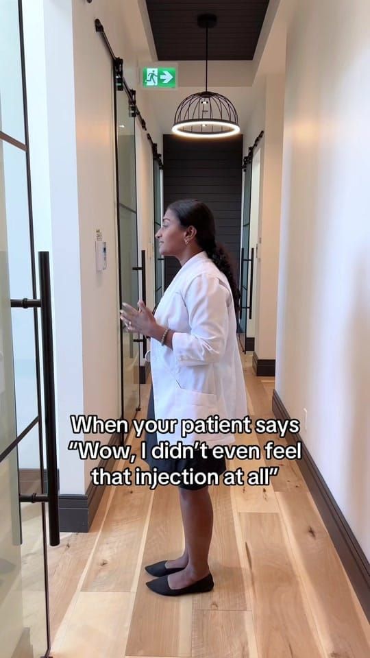 Dr. Sharon Barr in a white coat walks down the hallway at Longworth Dental Courtice with a small celebratory gesture.