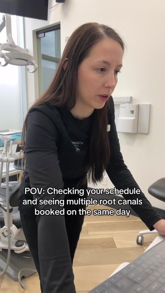 A Longworth Dental Courtice assistant leans over a workstation reading a screen with a worried expression.