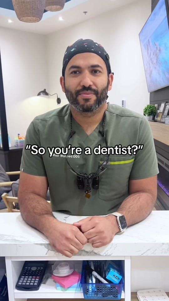 Dr. Zuhair Waheed in green scrubs and loupes at a counter at Longworth Dental Courtice, with on-screen text reading: 'So you're a dentist?'