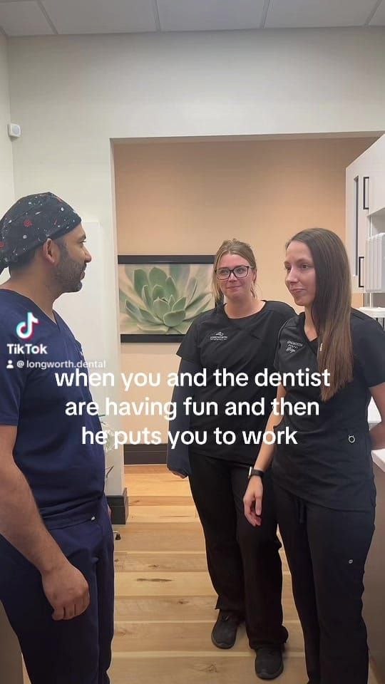 Dr. Zuhair Waheed in a surgical cap with two Longworth Dental Courtice team members.