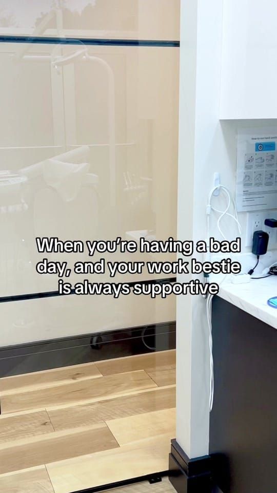 A Longworth Dental Courtice team member peeks around a wall holding a sign that reads 'Want me to pull the fire alarm?'