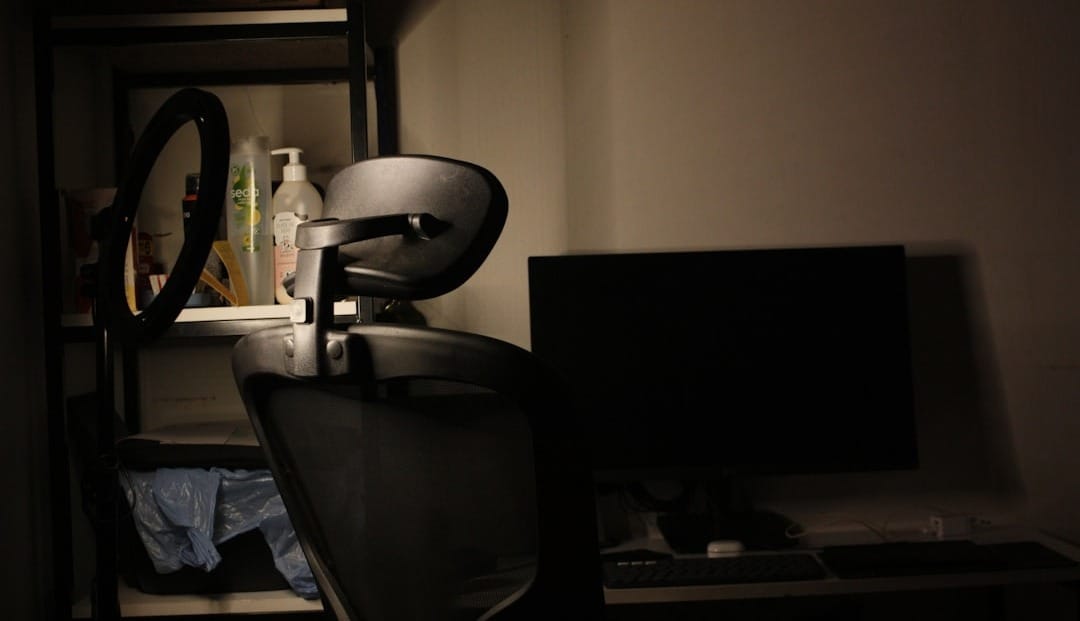 Desk with chair and computer in dim lighting