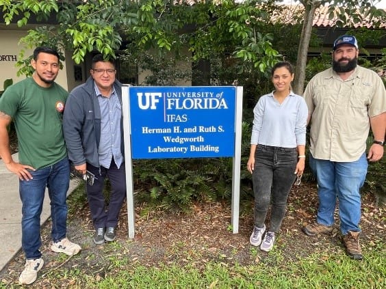 A group of people standing in front of a sign

AI-generated content may be incorrect.