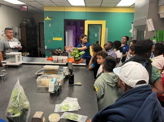 A group of people in a kitchen

AI-generated content may be incorrect.