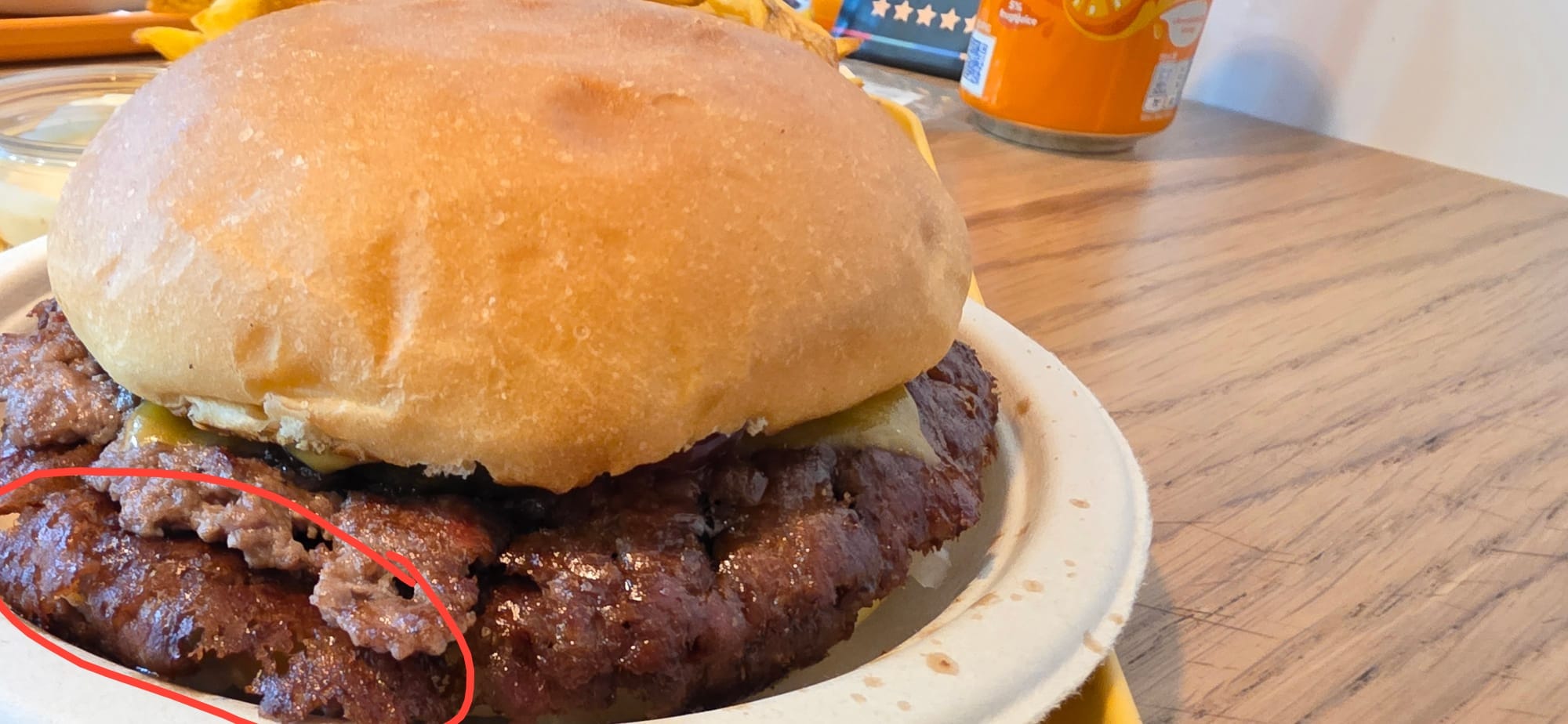 Un cheeseburger chez Sboom avec la partie croustillante de la viande mise en évidence.