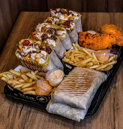 Plateau complet de french tacos avec frites, tenders et sauces.