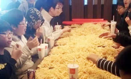 Des adolescents mangeant un énorme tas de frites en Corée du Sud.