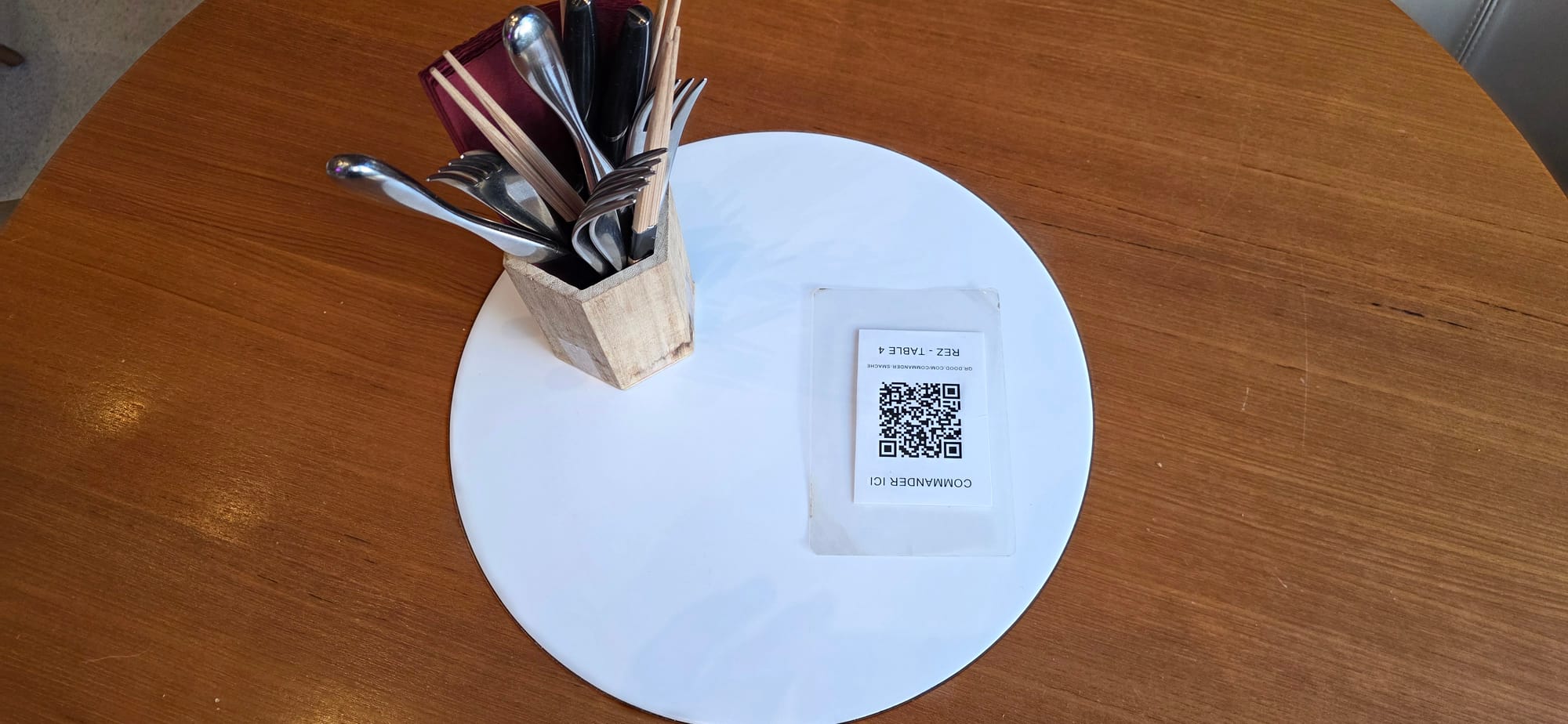 Couvertes et QR code sur une table chez Smache