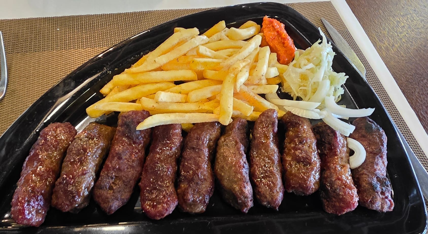 Frites, viandes, choux et sauce piquante chez New Adoc