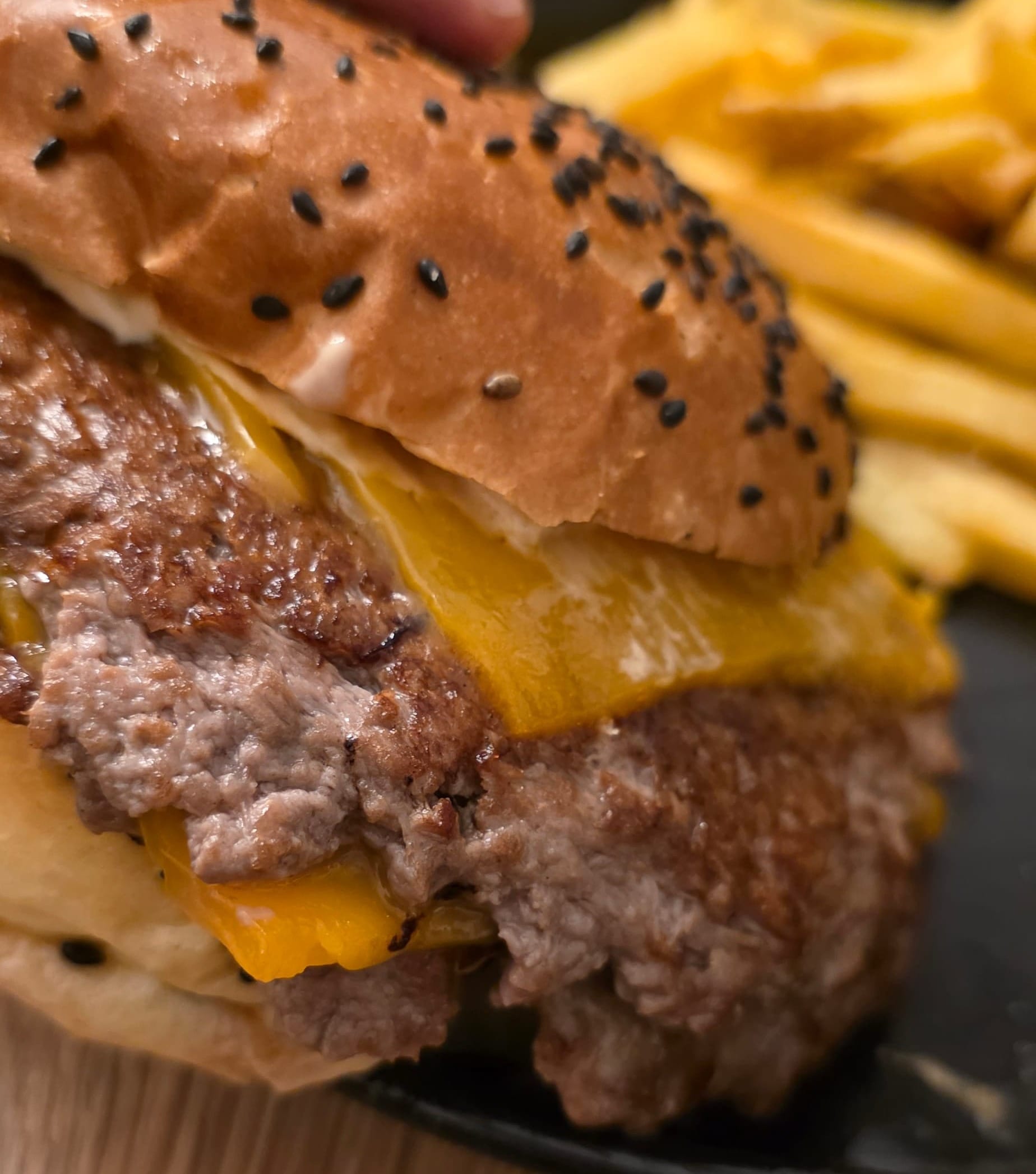 Gros plan sur la viande et sur le fromage du burger Maverick chez Qui Résiste à Lausanne.
