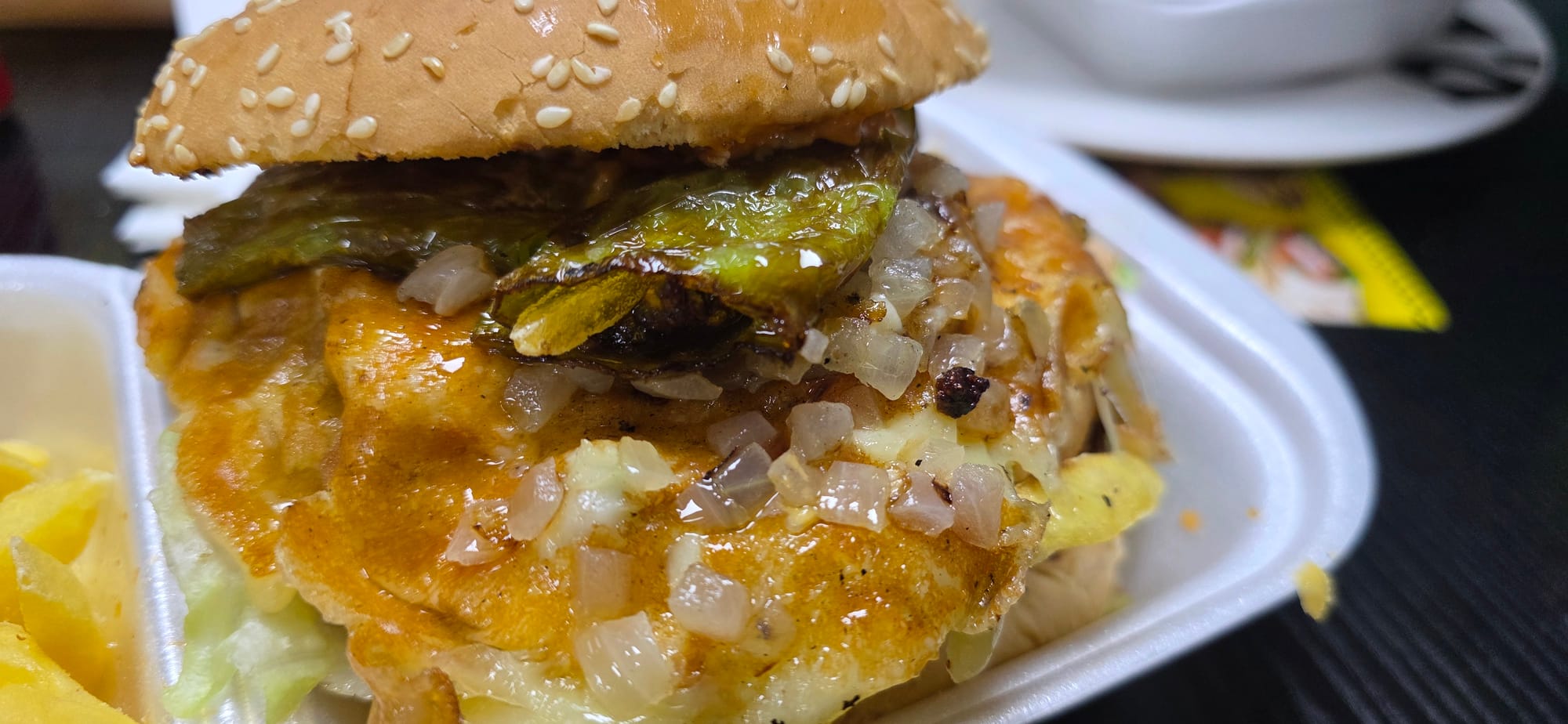 Gros plan sur le burger et son fromage fondu chez Taxi