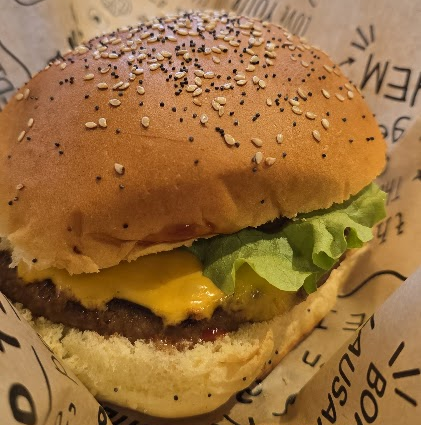 Le cheeseburger de chez Holy Cow à Lausanne, avec salade, fromage et viande de bœuf.