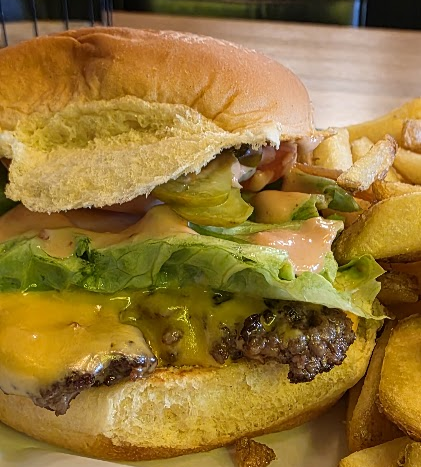 Un cheeseburger avec salade et frites chez Black Tap.