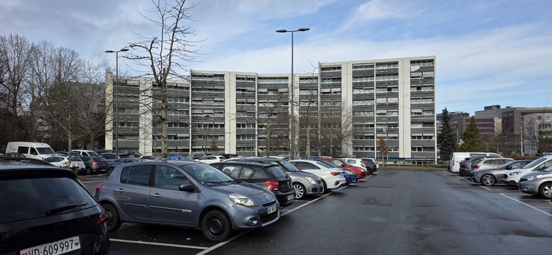 Parking avec immeuble gris à Renens.