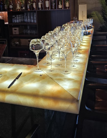Un bar illuminé avec des verres de vin.