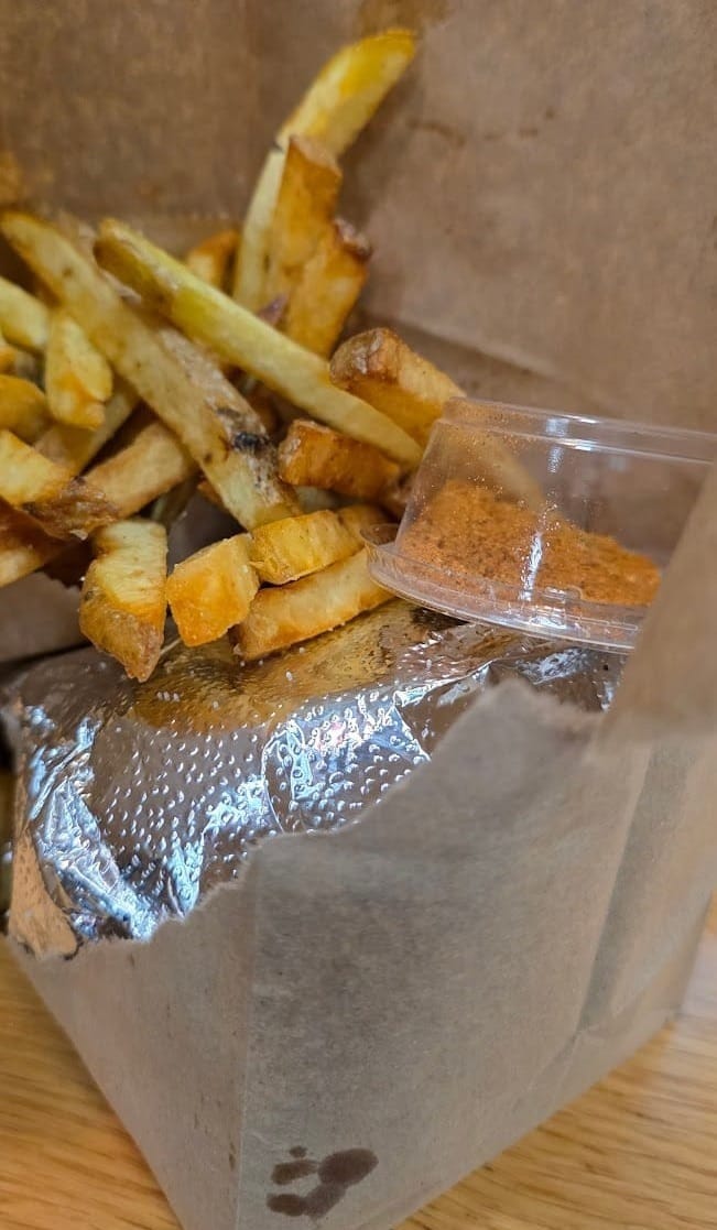 Les fameux sacs bruns de Five Guys avec frites, burgers et épices