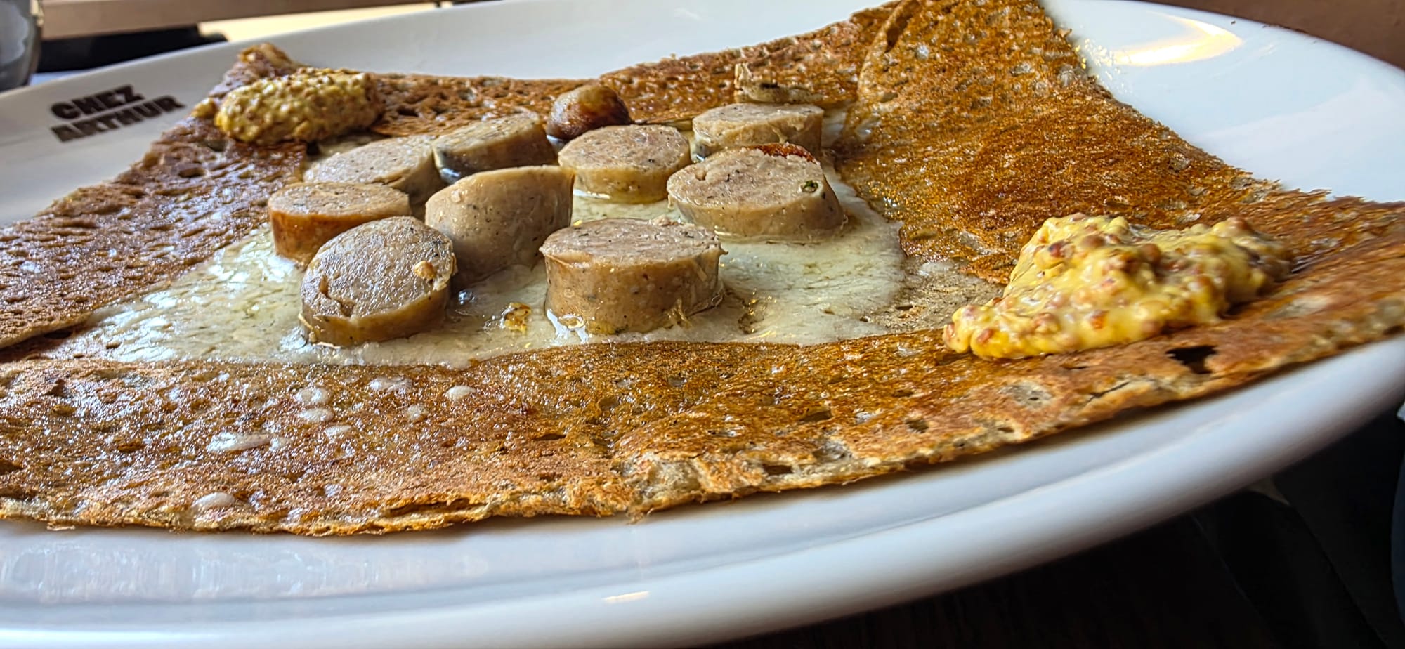 Une crêpe au sarrasin, à la saucisse et à la moutarde