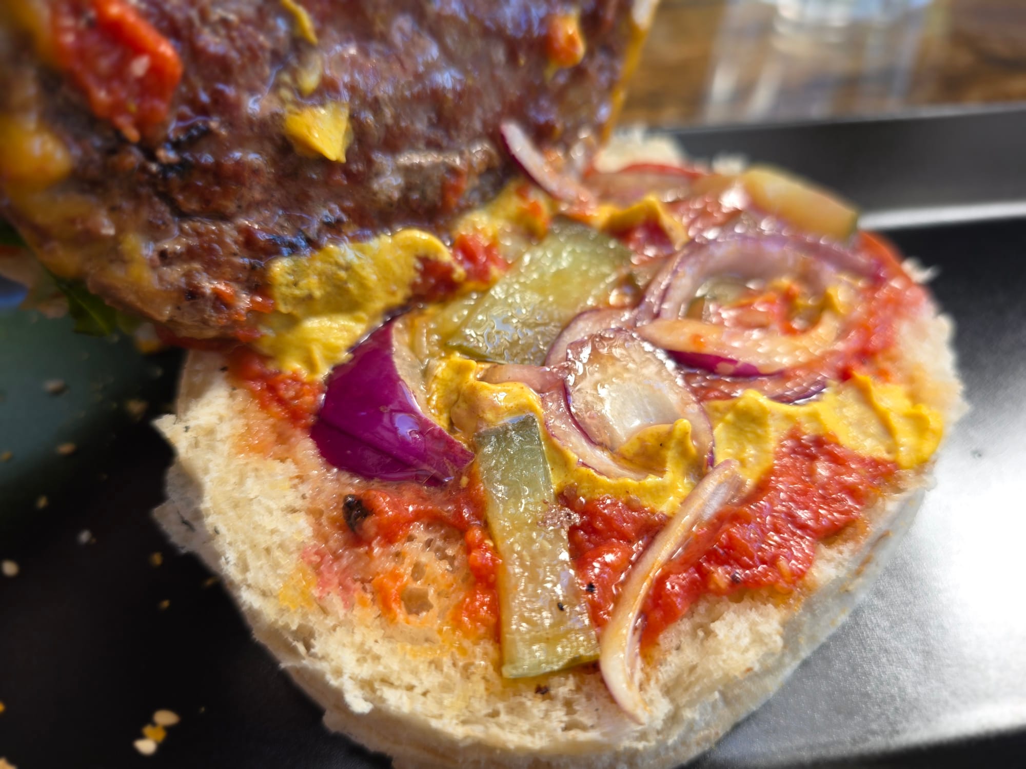 Gros plan sur les condiments du cheeseburger du Zoo Burger.