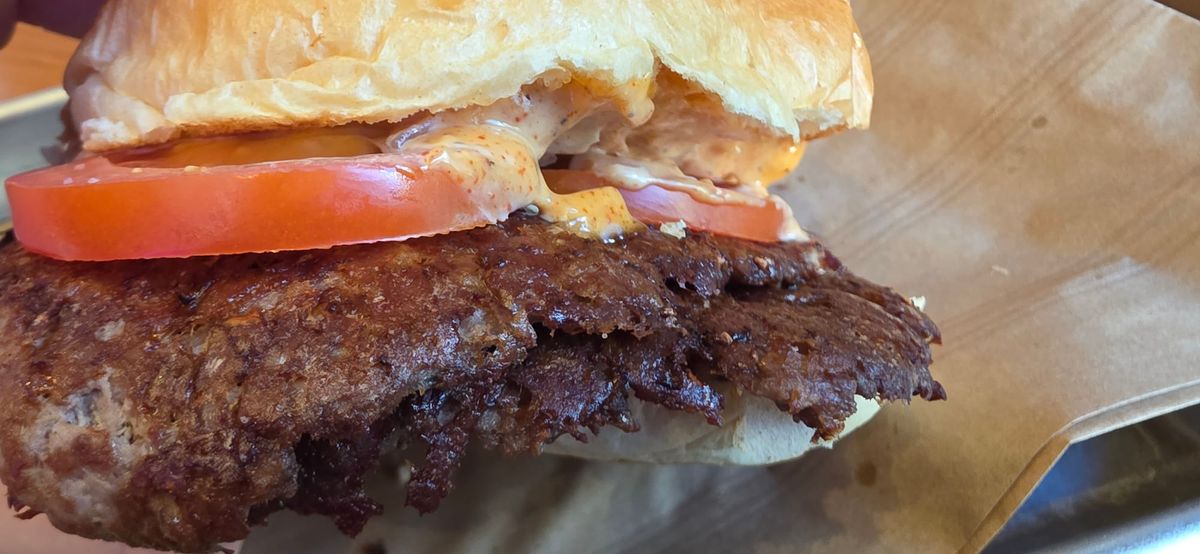 Gros plan d'un burger chez Smache. 