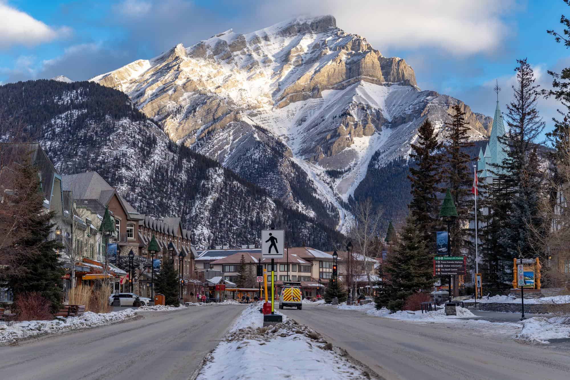 A road to Banff National Park with huge mountains in the background