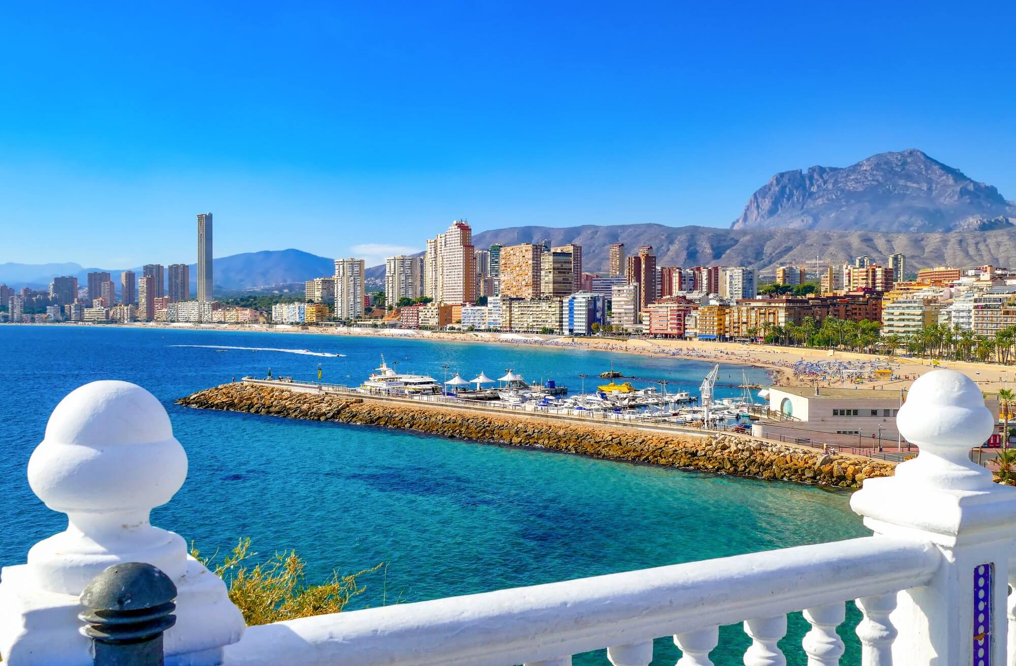 City views across the blue waters of a sandy beach