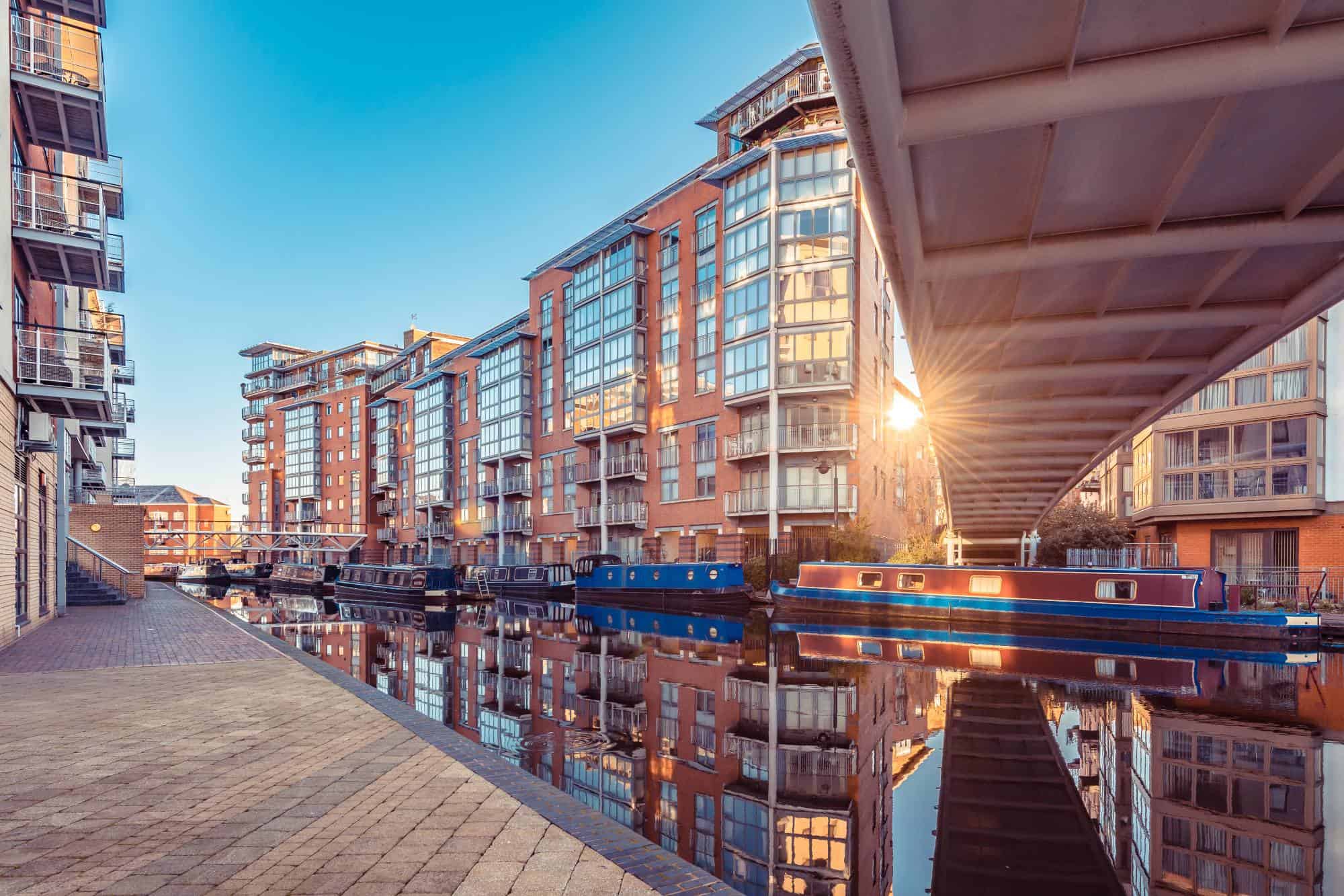 Narrow boats moored in Birmingham canal framed by city buildings