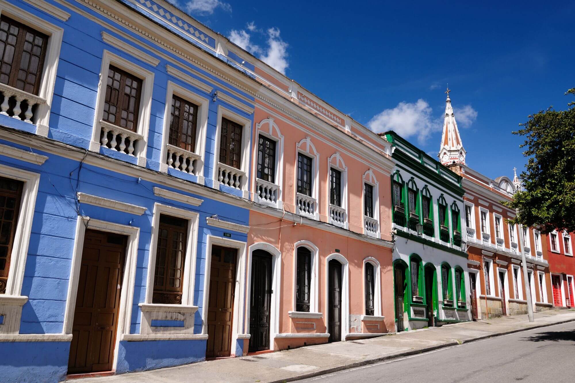 A historic street in Bogota, Colombia, with brightly colored two-storey residential houses