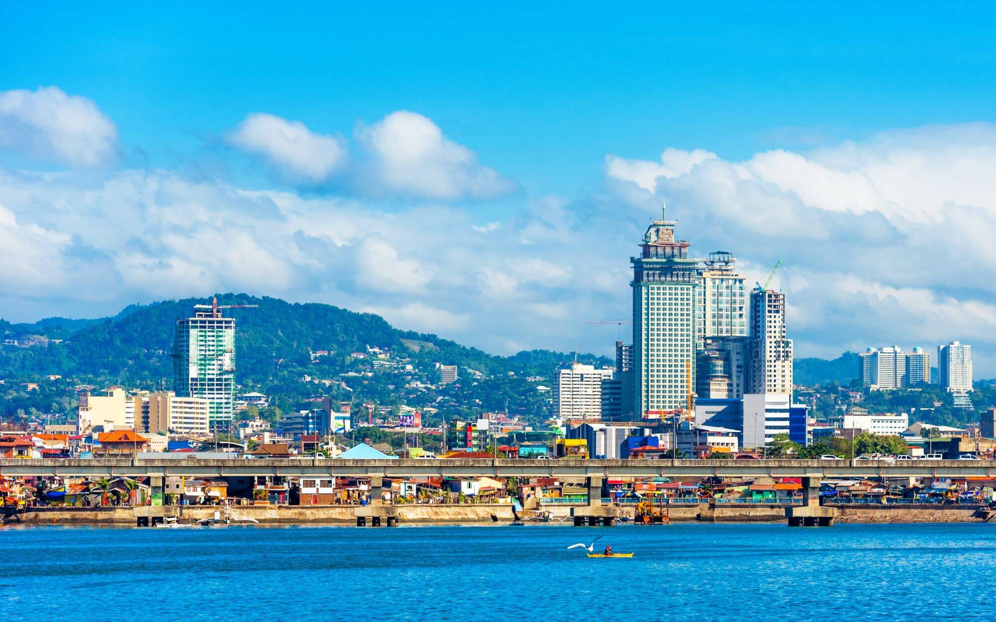 A modern coastal city - tall buildings and residential houses along the city beach in Cebu