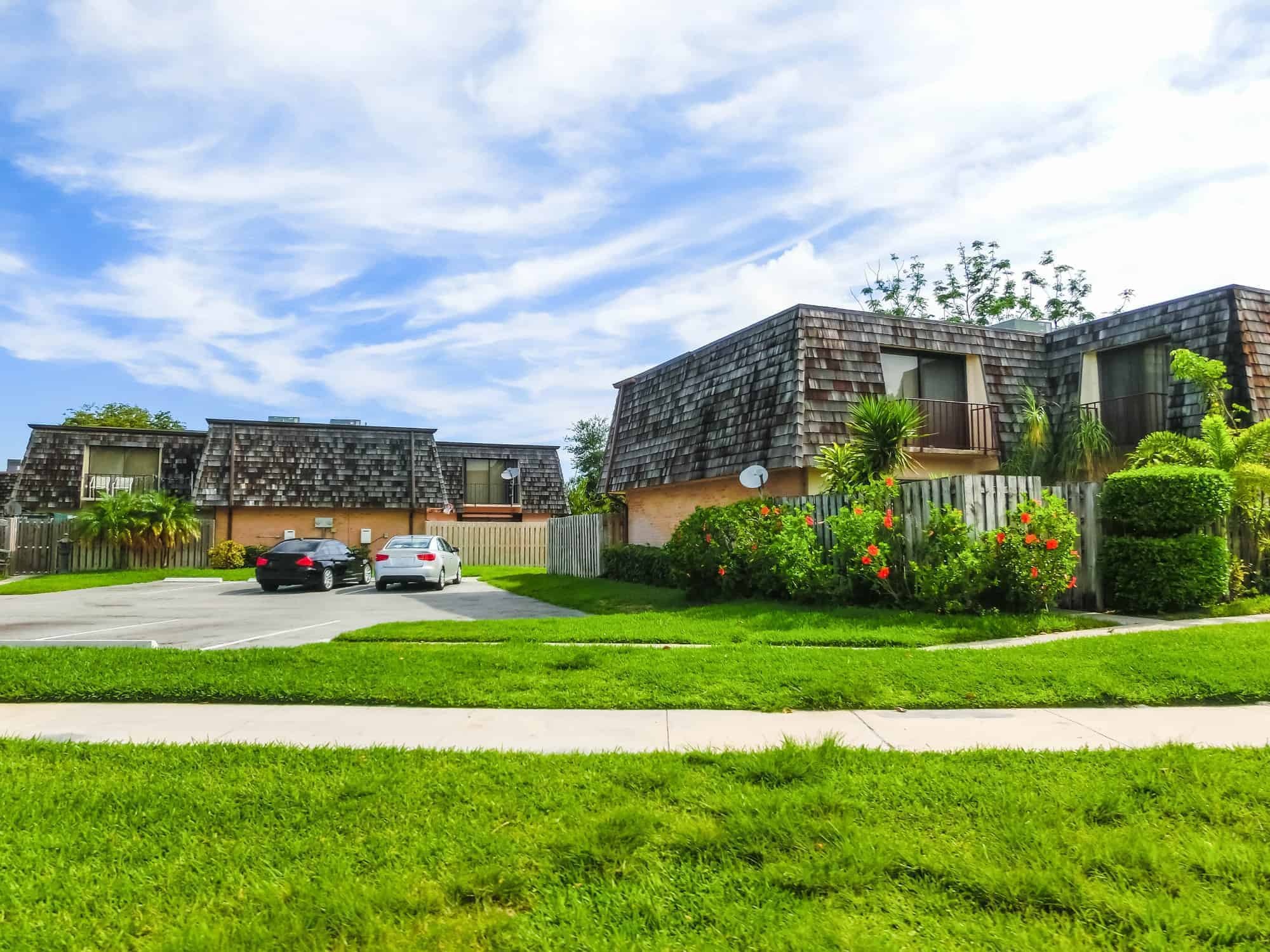 Typical Florida home in the countryside with palm trees, tropical plants, and flowers