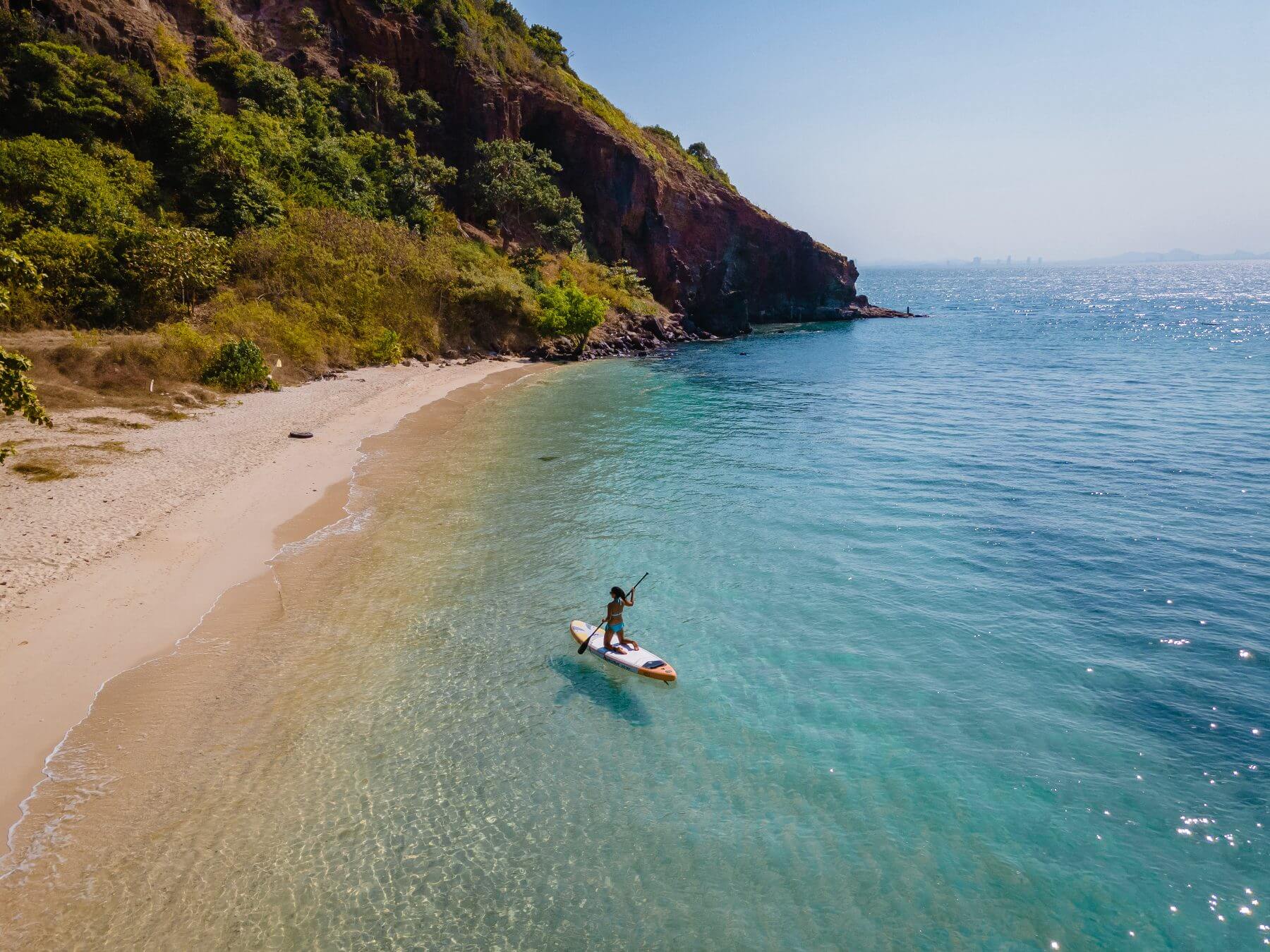 A girl paddle boarding by the beach in Koh Larn Island near Pattaya