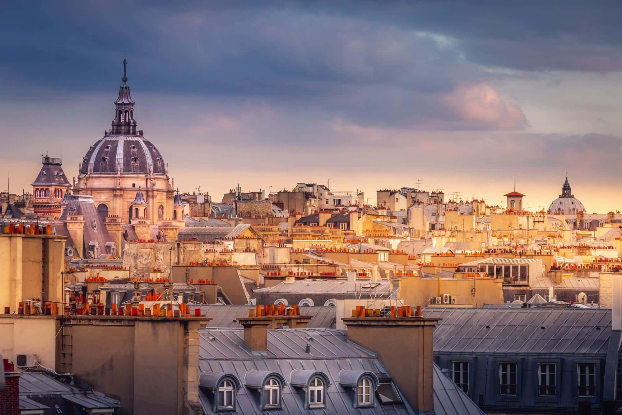 Roofs of the reidentisl buildings in Latin Quarter, Paris lit up by the setting sun
