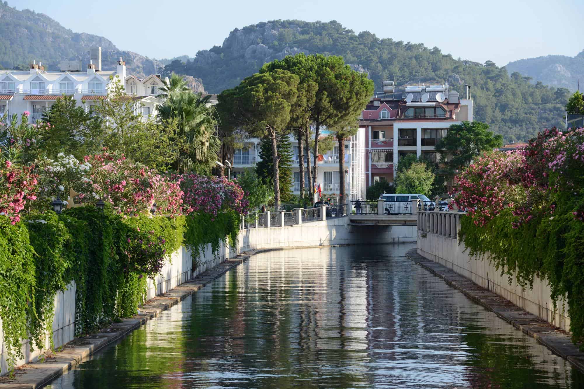 Marmaris, houses along the canal with kush green gardens and hills in the background.