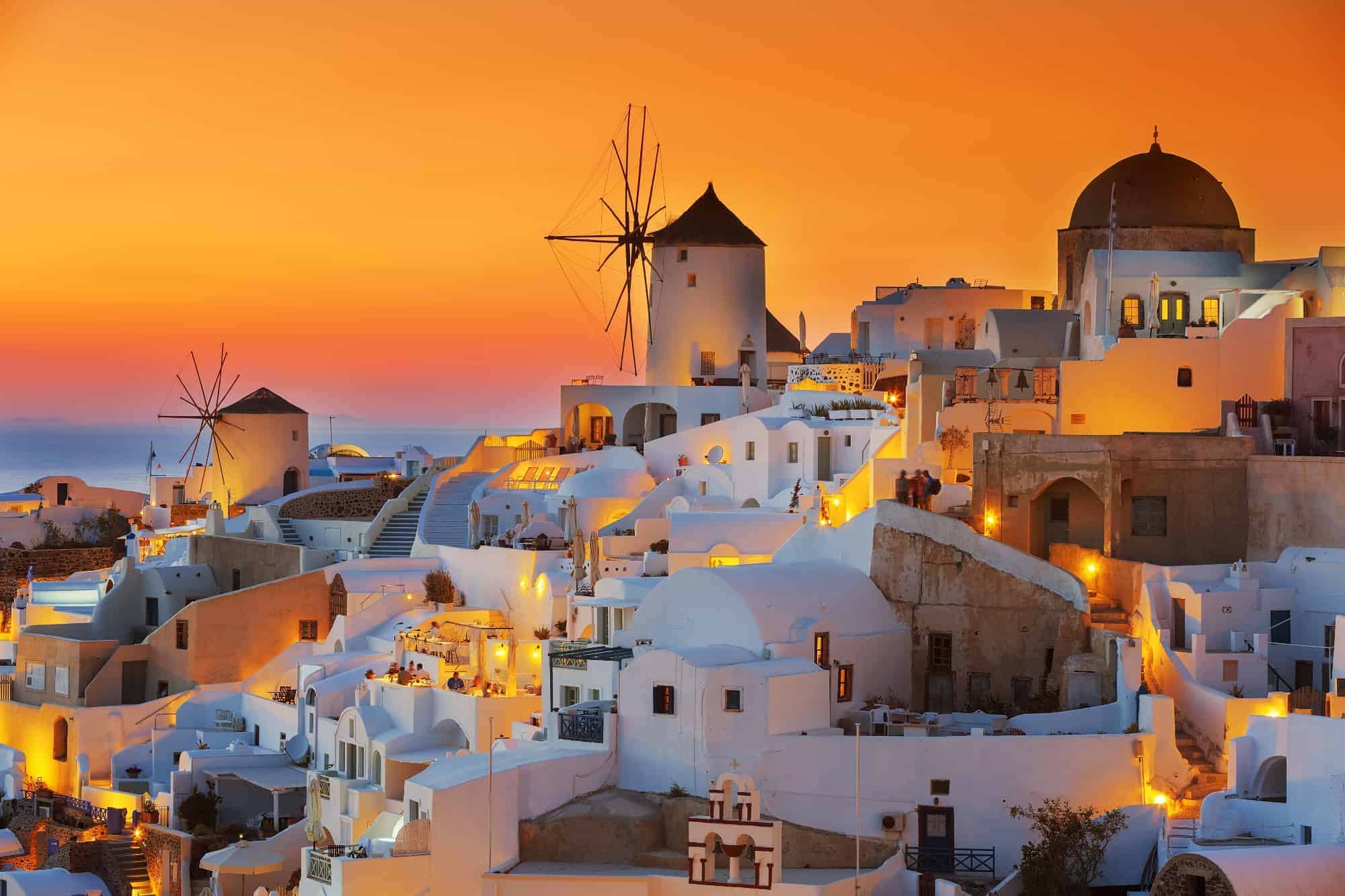 Sunset in Satorini - golden glow over the white houses and windmills