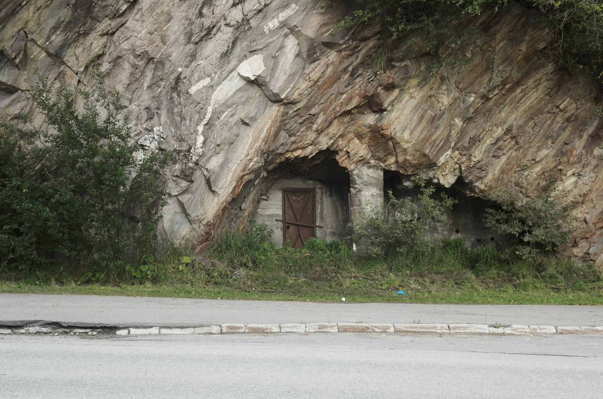 An iron door in a rock wall cave.