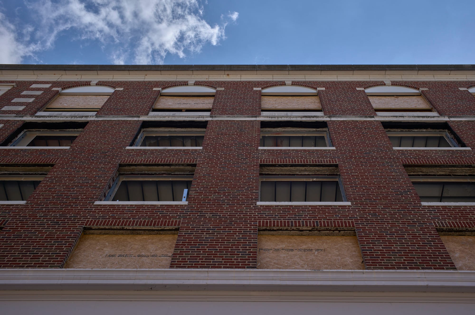 An olde building looking up and windows removed for renovation
