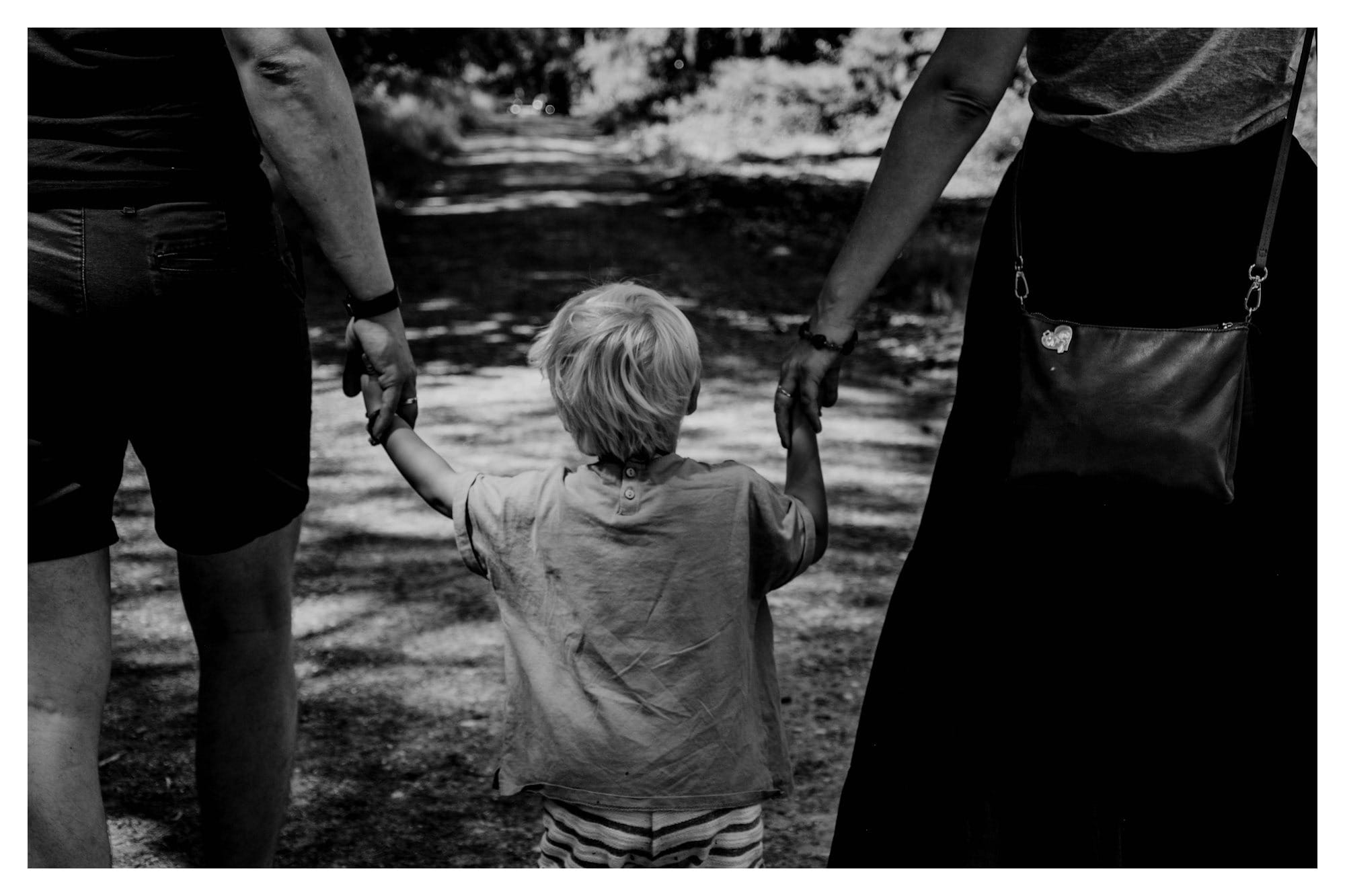 grayscale photo of woman in black dress holding child in black shirt